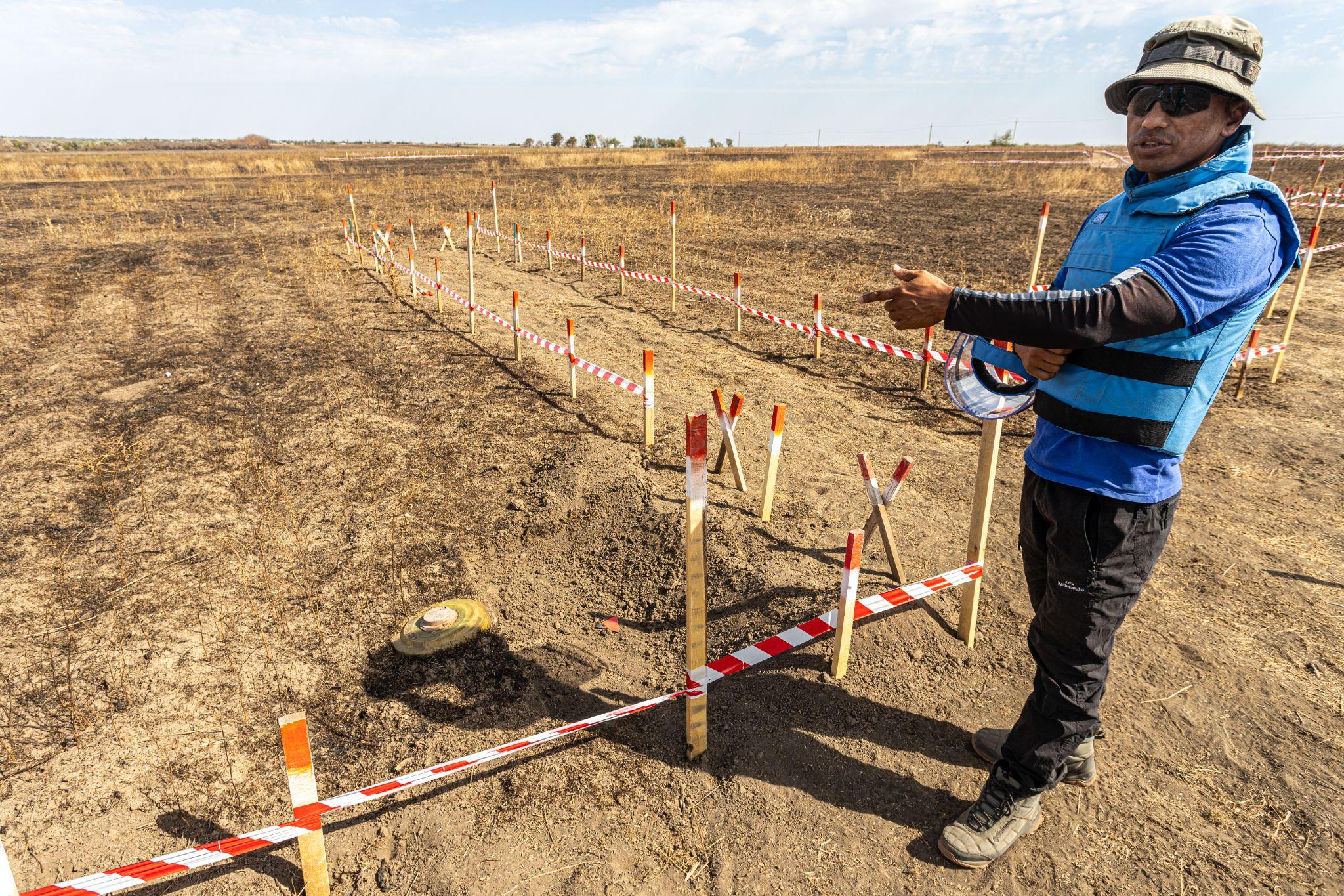 A team leader shows a TM-62 anti-tank mine in a contaminated area. Demining in Ukraine during the full-scale Russian invasion