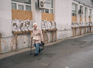 wp russian drones targeting kherson civilians ongoing human safari woman walks past windows covered wooden planks sandbags outside hospital