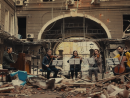 Ukrainian musician Slava Vakarchuk of Okean Elzy with an orchestra on the ruins of a building destroyed by Russians.