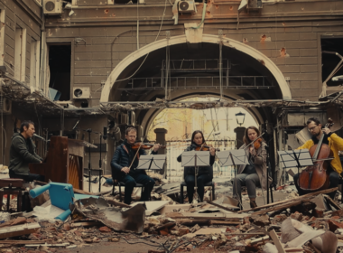 Ukrainian musician Slava Vakarchuk of Okean Elzy with an orchestra on the ruins of a building destroyed by Russians.