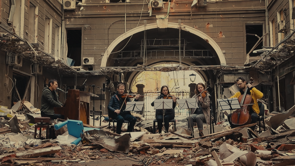 Ukrainian musician Slava Vakarchuk of Okean Elzy with an orchestra on the ruins of a building destroyed by Russians.