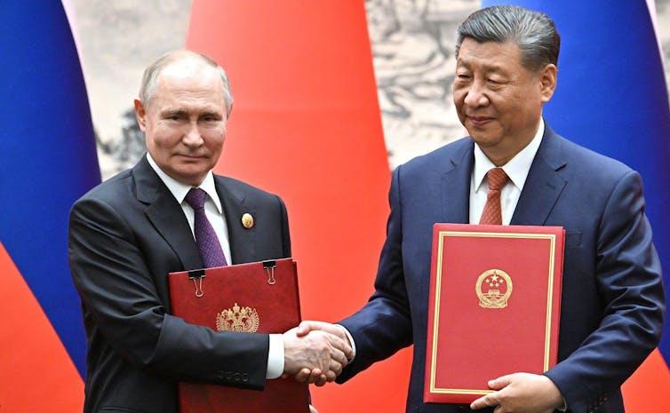 Vladimir Putin shaking hands with President Xi