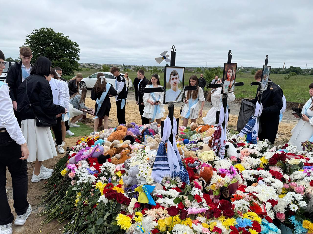 Ukrainian high school students visit a gravesite of their classmate and his two siblings killed by a Russian missile strike. Their class teacher conducts a "last bell" graduation ceremony for the oldest of the siblings, Roman.