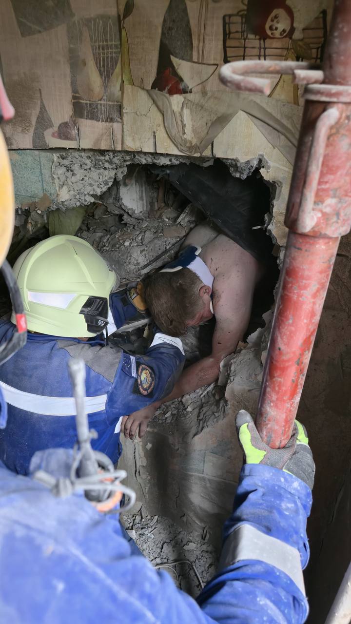 A rescuer pulls a man out from a collapsed apartment section in Kyiv after hours of digging through debris in Kyiv. 31 July 2025 Source: Ihor Klymenko