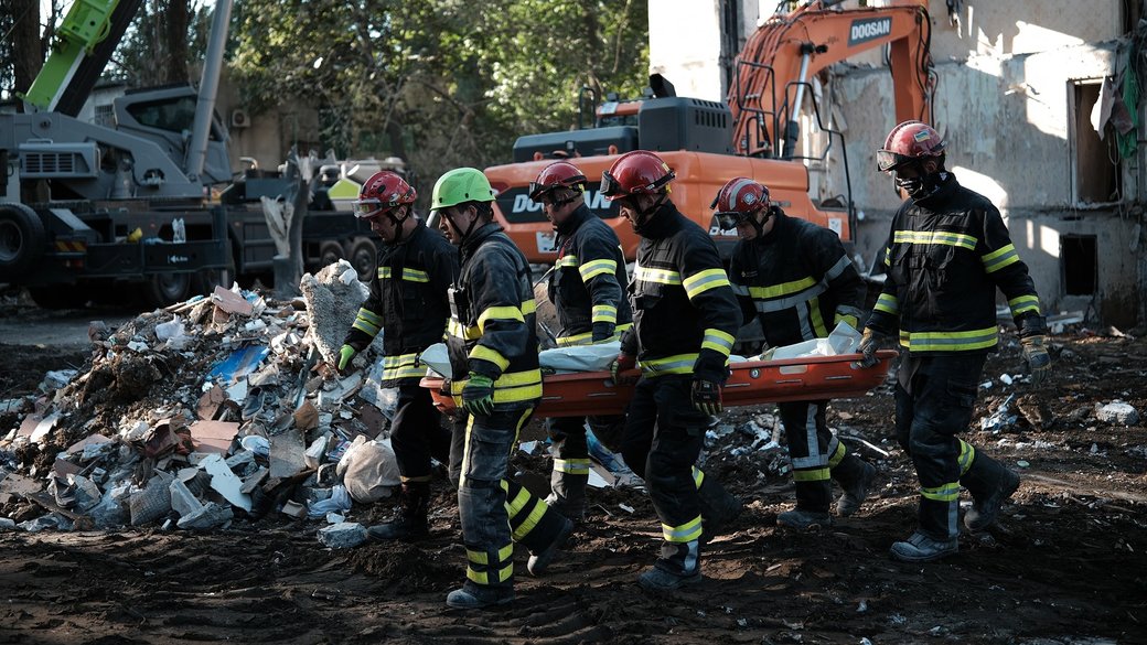 Rescuers carry a body recovered from the death toll yesterday's russian air assault kyiv reaches 31 2‑year‑old among victims city mourns local woman stands site search rescue operations near destroyed residential building sviatoshynskyi district 1 2025 suspilne/nikita rubble of a destroyed building in Sviatoshynskyi district of Kyiv on 1 August 2025. Source: State Emergency Service of Ukraine.