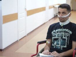 Ukrainian soldier Vladyslav sits in his wheelchair at the hospital, communicating through written notes after Russian forces cut his throat during torture and left him in a pit with corpses of other killed Ukrainian fighters, thinking he was dead. The 33-year-old National Guard soldier survived and crawled for five days to safety.