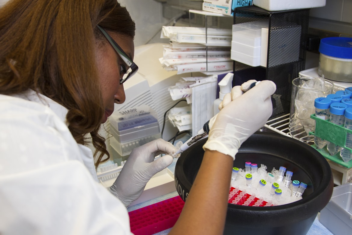 woman in white shirt pipetting a samples into a tube