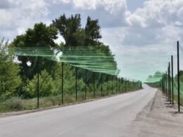 Netting tunnel over a road in Zaporizhzhia, protecting civilians and vehicles from FPV drone attacks.