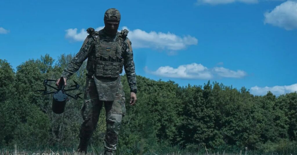A Ukrainian soldier carries an FPV drone.