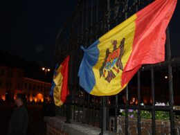 Moldovan and Romanian flags on a fence.