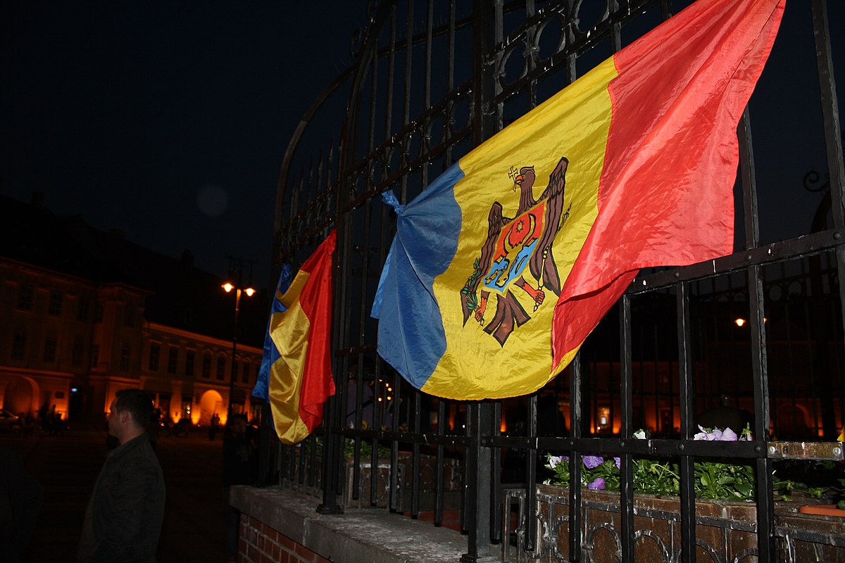Moldovan and Romanian flags on a fence.