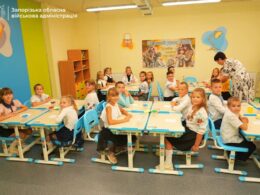 Children seated at desks inside an underground classroom in Zaporizhzhia, attending lessons in a secure school facility.