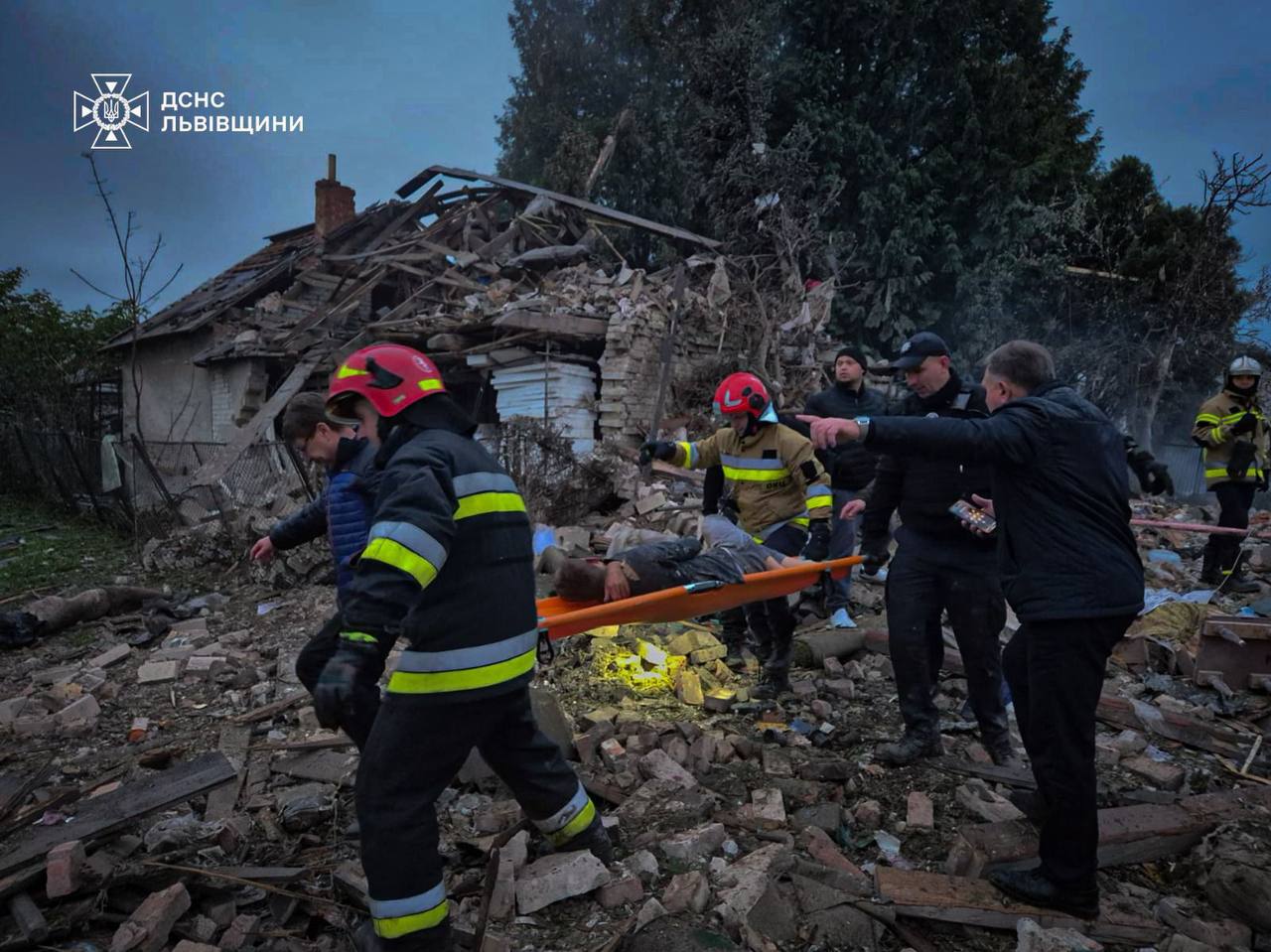 Emergency workers evacuate an injured person from a destroyed home in Lviv Oblast following the Russian attack on 5 October that killed a family of four, including a 15-year-old girl.