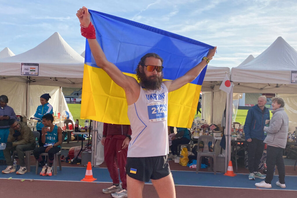 Andriy Tkachuk holds the Ukrainian flag after winning the 24-hour ultramarathon world championship in Albi, France, covering 294.346 kilometers.