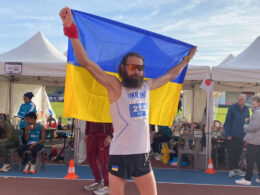 Andriy Tkachuk holds the Ukrainian flag after winning the 24-hour ultramarathon world championship in Albi, France, covering 294.346 kilometers.