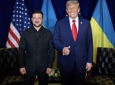 Ukrainian President Volodymyr Zelenskyy and US President Donald Trump stand together in front of Ukrainian and US flags after their meeting