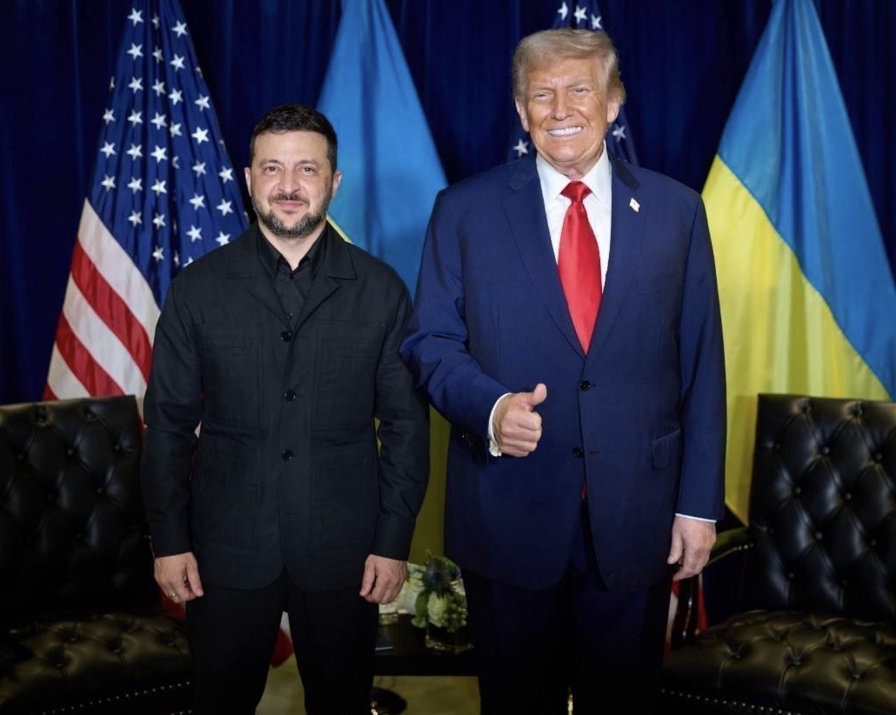 Ukrainian President Volodymyr Zelenskyy and US President Donald Trump stand together in front of Ukrainian and US flags after their meeting