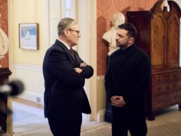UK Prime Minister Keir Starmer (left) and Ukrainian President Volodymyr Zelenskyy (right) stand talking face-to-face inside a formal room at Downing Street