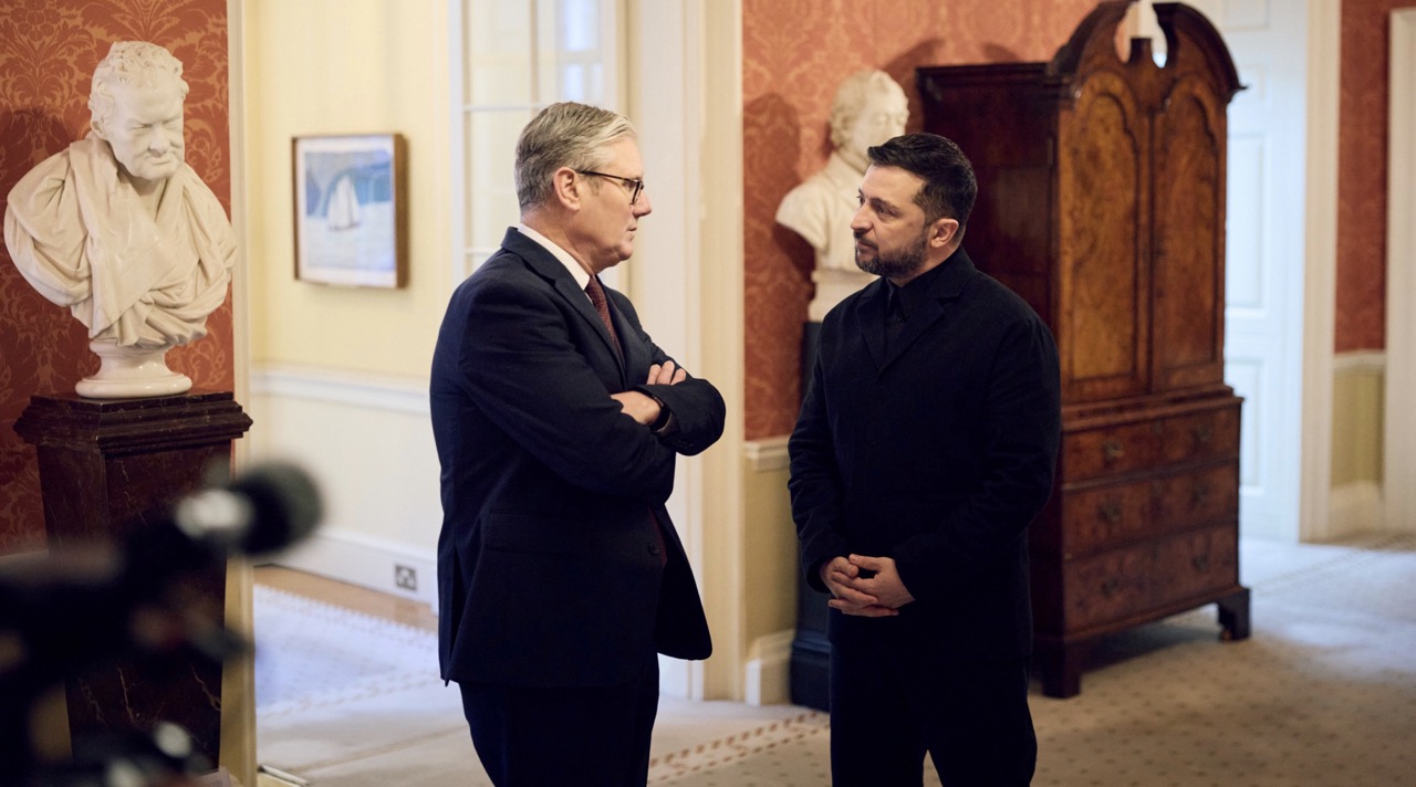 UK Prime Minister Keir Starmer (left) and Ukrainian President Volodymyr Zelenskyy (right) stand talking face-to-face inside a formal room at Downing Street