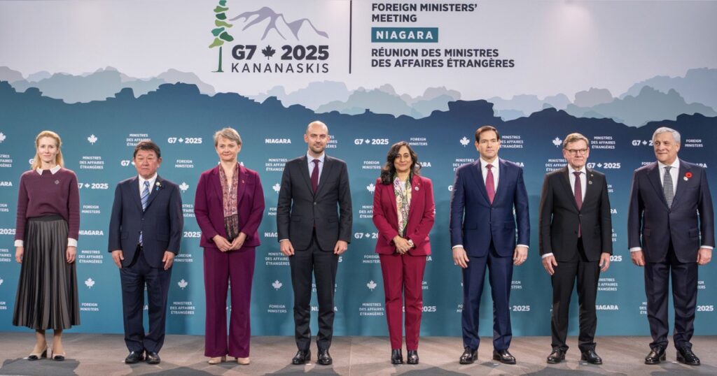 Nine foreign ministers from G7 nations and EU standing in formal group photo against teal backdrop with G7 2025 Kananaskis logo and mountain graphics at Niagara Foreign Ministers' Meeting