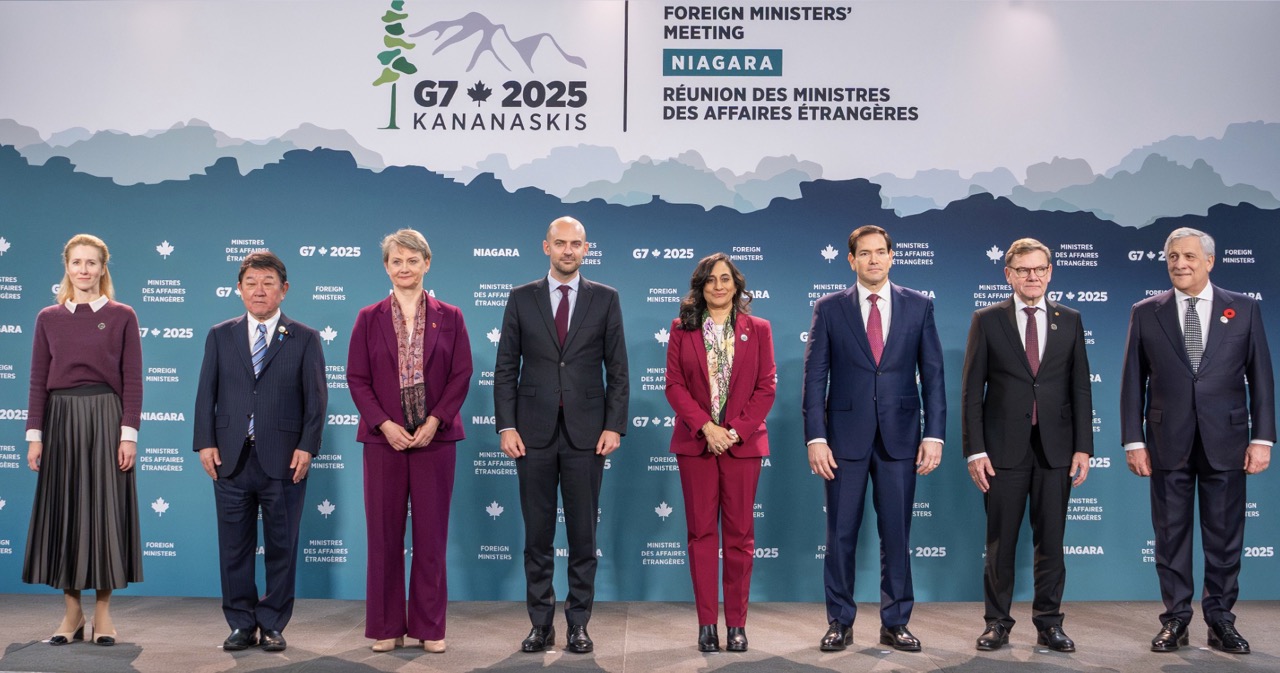 Nine foreign ministers from G7 nations and EU standing in formal group photo against teal backdrop with G7 2025 Kananaskis logo and mountain graphics at Niagara Foreign Ministers' Meeting