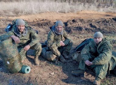 Foreign mercenaries in Russian military uniforms sitting on the ground with rucksacks