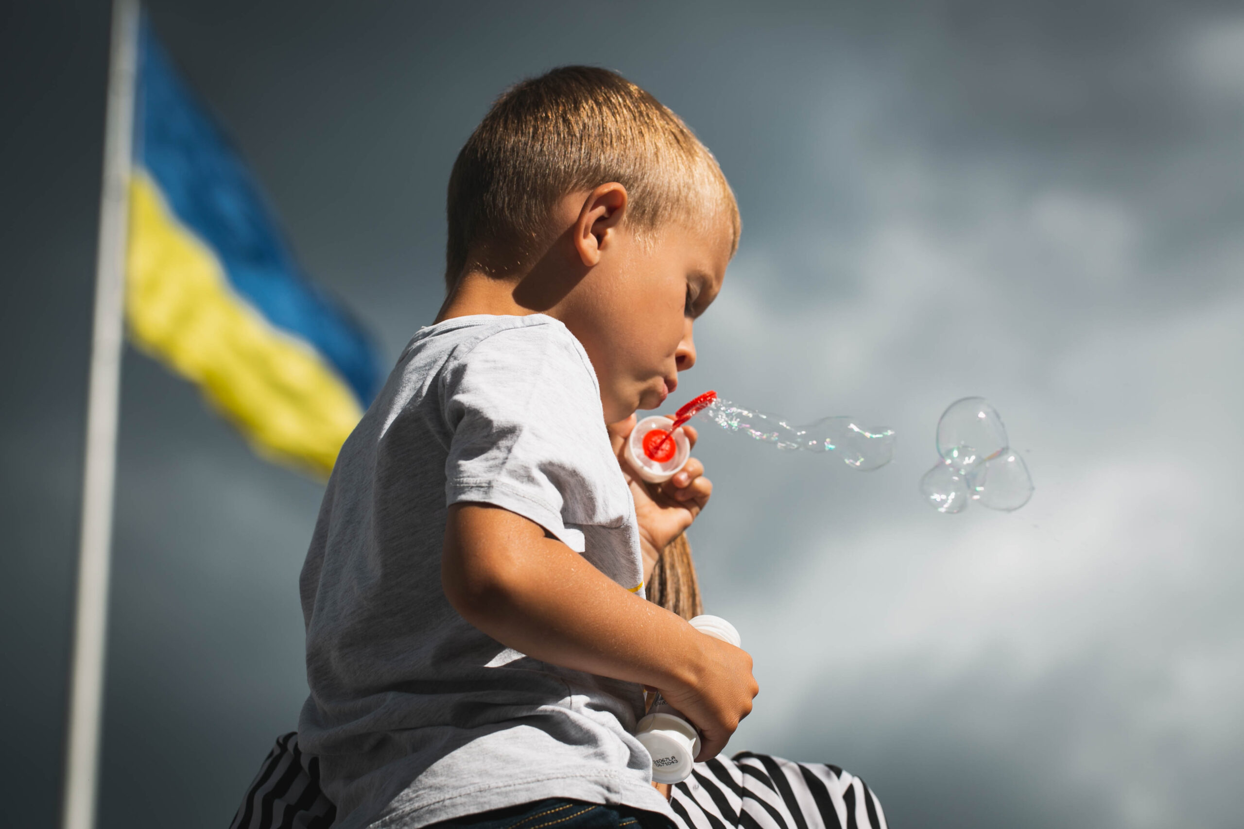 Ukrainian child blows bubbles Ukrainian flag boy children kids