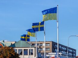 Ukrainian and Swedish flags in strong wind at the south harbor in Lysekil, Sweden.