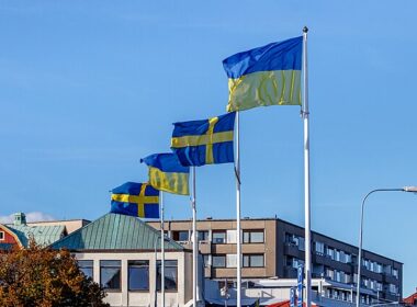 Ukrainian and Swedish flags in strong wind at the south harbor in Lysekil, Sweden.
