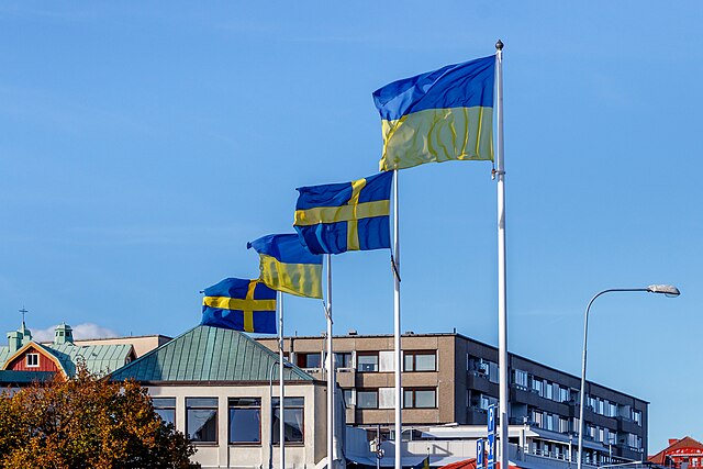 Ukrainian and Swedish flags in strong wind at the south harbor in Lysekil, Sweden.