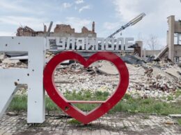 The "I ♥ Huliaipole" sign stands in front of destroyed buildings in Huliaipole, Zaporizhzhia Oblast