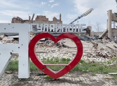 The "I ♥ Huliaipole" sign stands in front of destroyed buildings in Huliaipole, Zaporizhzhia Oblast