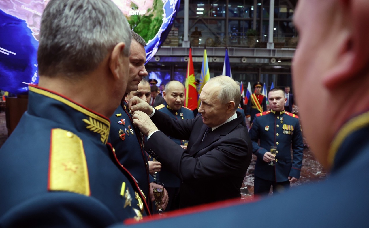 Russian President Vladimir Putin pins a medal on a servicemember during an awards ceremony on 17 December 2025, surrounded by military officers in dress uniforms