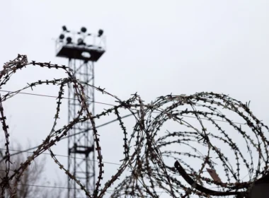 Barbed wire and watchtower at a prison facility. Freed Ukrainian civilians describe systematic torture in Russian detention centers from Donetsk to Siberia.