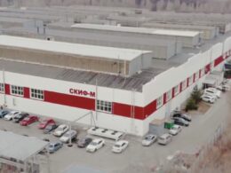 Aerial view of the SKIF-M machine tool plant in Belgorod, Russia, showing the main production building with red and white facade and company logo