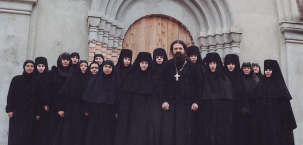 Archpriest Andrey Lemeshonok stands with nuns from St. Elisabeth Convent in Belarus outside a church entrance. Sweden has warned parishes against hosting the convent's fundraising operations.