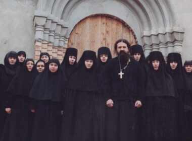 Archpriest Andrey Lemeshonok stands with nuns from St. Elisabeth Convent in Belarus outside a church entrance. Sweden has warned parishes against hosting the convent's fundraising operations.