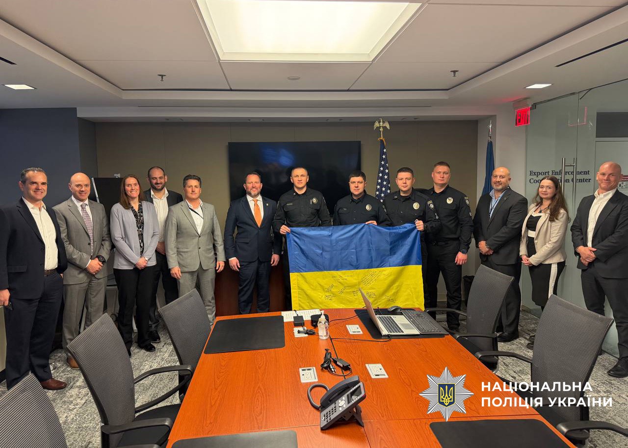 Ukrainian police officers in uniform hold a Ukrainian flag alongside American officials in a Washington conference room
