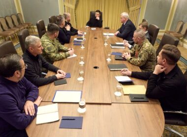 Ukrainian President Volodymyr Zelenskyy meets with his negotiating delegation around a conference table, including military officials in uniform and civilian advisors, during a briefing on US peace talks, 02 December 2025