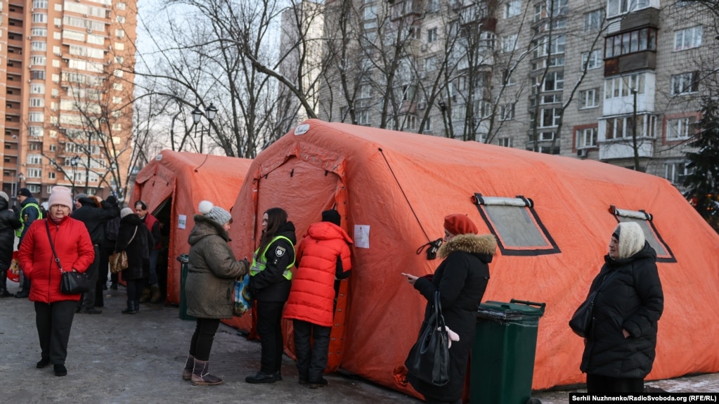 kyiv restores heating hundreds apartment blocks after russian attacks -15°c cold persists · post people wait outside mobile point where residents can warm up drink tea charge phones get help