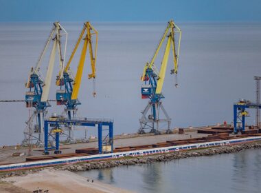 Cranes at Mariupol seaport with "Mariupol is Russia" slogan painted in Russian flag colors on the dock, 2025