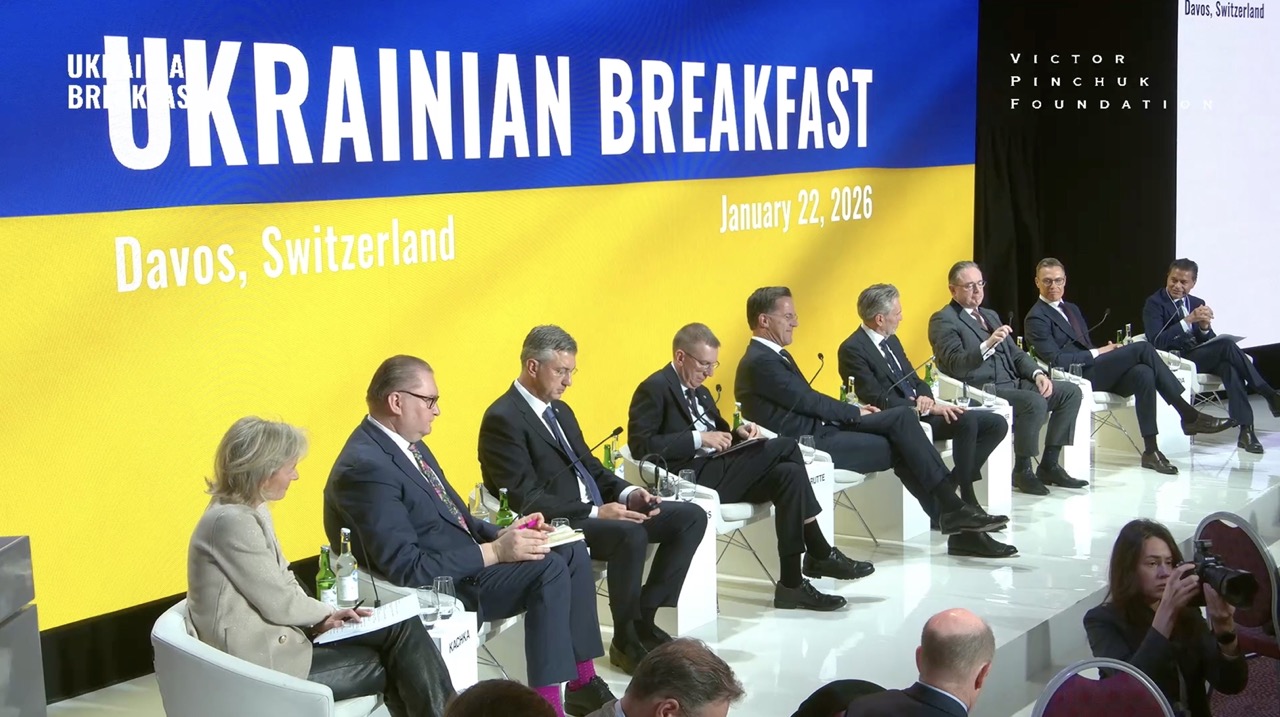 European and US officials seated on stage at the Ukrainian Breakfast in Davos, with Ukraine's blue and yellow colors displayed on the backdrop, January 2026