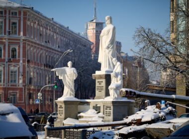 Destroyed Russian military equipment displayed in the snow near the Princess Olga Monument in Kyiv, with historic buildings in the background
