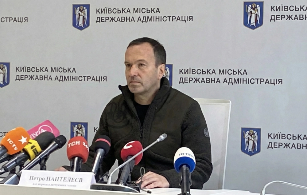 Petro Panteleiev speaking at a press briefing at Kyiv City State Administration, microphones from Ukrainian TV channels visible