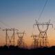 Nordic energy infrastructure power grid transmission towers silhouetted against sunset sky