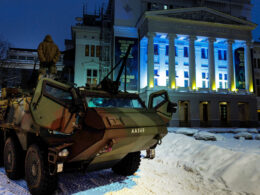 €500000 60 seconds — latvians buying robots get wounded soldiers out drone kill zones · post military armored vehicle front latvian national opera lit ukrainian flag colors ahead aizved mani