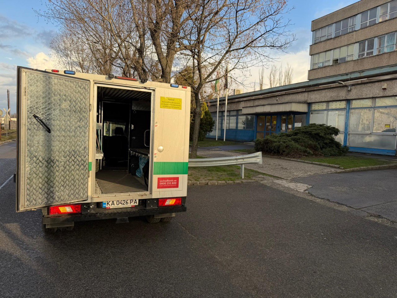 Rear view of an Oschadbank armored cash-in-transit vehicle with doors open and cargo compartment empty, returned by Hungary on 12 March 2026 with documented equipment damage.