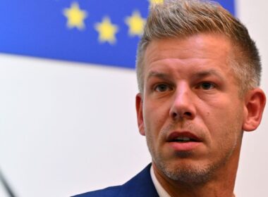 Péter Magyar, leader of Hungary's opposition Tisza party, speaks at a press conference in front of a European Union flag.