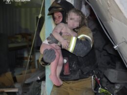 A rescue worker carries a child out of a building damaged in a Russian attack in Odesa. 6 April 2026. Credits: State Emergency Service of Odesa Oblast