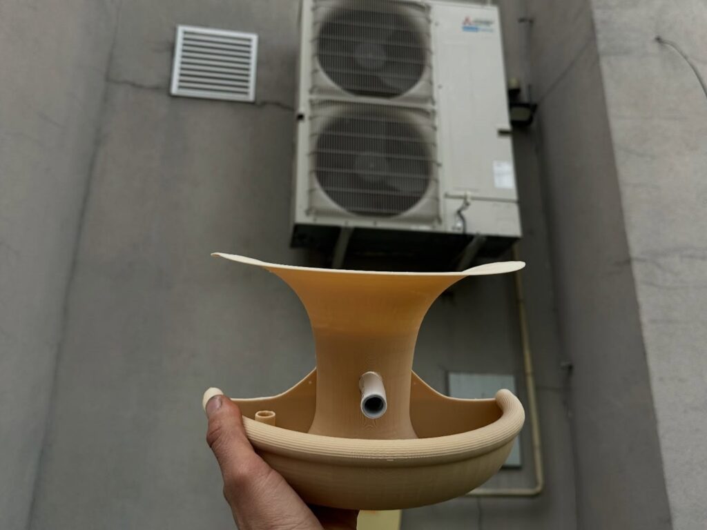 A 3D-printed feeder that collects condensation water from air conditioner units for urban birds as part of Ukraine’s “Drops of Life” initiative.